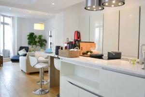 a kitchen with a counter and a living room at Appartement Centre-ville spacieux, élégant / Climatisation in Montpellier