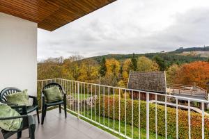 balcón con sillas y vistas a un bosque en Haus Anna, en Kirchhundem