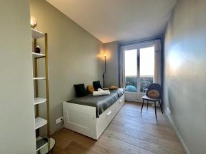 a small bedroom with a bed and a window at Quai de Seine - Vue sur la Seine in Boulogne-Billancourt