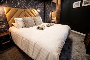 a bedroom with a large bed with white sheets and a mirror at VIP - 2 BR Grade 2 Luxury Industrial House with Log Burning FIRE & electric blinds in the Heart of the JQ in Birmingham