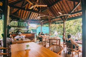 a group of people sitting at tables in a restaurant at Unique Stays at Karuna El Nido - The Pyramid in El Nido