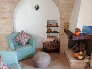 sala de estar con silla azul y chimenea en ANPEMO Casa Vacanze, en Silvi Paese