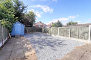 a backyard with a blue shed next to a fence at Highfield House cosy 4 bedroom in Scunthorpe