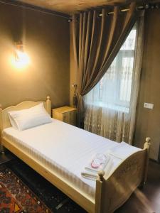 a bed in a room with a window with a white mattress at YAKKA MINOR in Samarkand