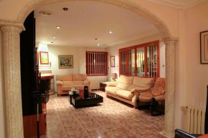 Sala de estar con 2 sofás y mesa en Villa Iluminada con piscina y barbacoa cerca Playa, en Elche