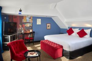 a bedroom with a large bed and red chairs at Hotel Les Théâtres in Paris
