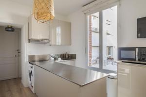 uma cozinha com um balcão de aço inoxidável e um micro-ondas em Les Carmélites - Appartements dans l'hyper-centre de Rennes em Rennes