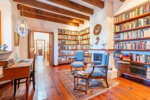 a library with two chairs and a desk and bookshelves at Casa Amber in Sóller