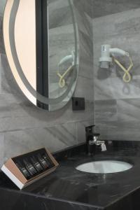 een badkamer met een wastafel en een spiegel bij Isle Hotel in Istanbul