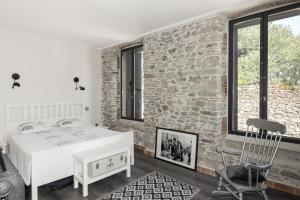 Zimmer mit einer Steinmauer, einem Tisch und einem Stuhl in der Unterkunft La Number One en Minervois, piscine privee in Peyriac-Minervois