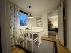 a white table and chairs in a room with a window at Cozy little cottage in the middle of Gotland near Visby in Visby