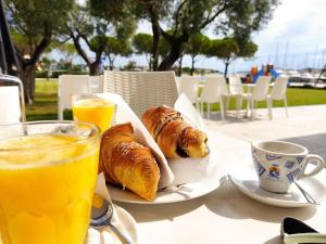 einen Tisch mit 2 Platten Gebäck und einer Tasse Orangensaft in der Unterkunft Signora Ruth - Aprilia Residence in Aprilia Marittima