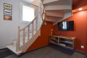 een woonkamer met een trap en een flatscreen-tv bij La Fangousse, proche Lac Pareloup in Salles-Curan