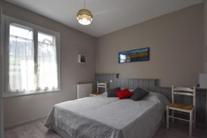 een slaapkamer met een bed en 2 ramen bij La Fangousse, proche Lac Pareloup in Salles-Curan