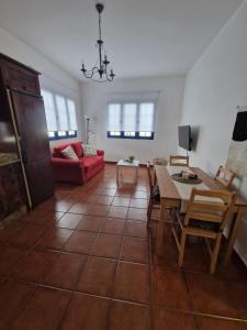 Casa Calandrilla في Caleta de Caballo: غرفة معيشة مع طاولة وأريكة حمراء