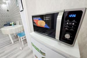 タシュケントにあるCozy New Apartment in a Quite Neighborhoodの白い冷蔵庫の上に電子レンジ +15枚の写真