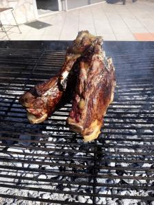 two pieces of meat cooking on a grill at Bici Grill Decimo Miglio in Ciampino