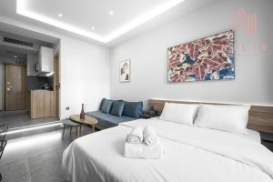 a bedroom with a white bed and a blue couch at Pantheon, Nilie Hospitality MGMT in Thessaloniki