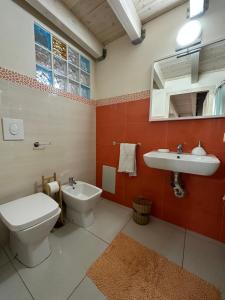 bagno con servizi igienici, lavandino e specchio di O' Vascio House a Napoli