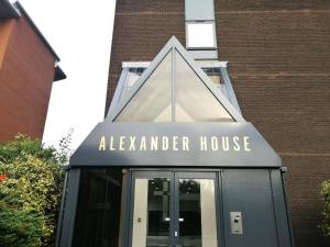 Um edifício com um sinal para a casa de aaza. em Brand New Trafford Apartment em Manchester
