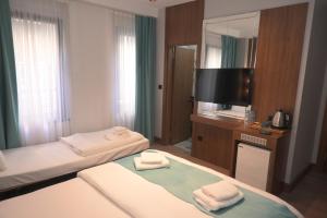 pokój hotelowy z 2 łóżkami i telewizorem z płaskim ekranem w obiekcie Isle Hotel w Stambule