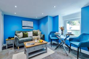 un soggiorno con pareti blu, divano e tavolo di Finest Retreats - Abbey Road House a Llandudno