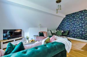 un soggiorno con divano verde e TV di Finest Retreats - Abbey Road House a Llandudno