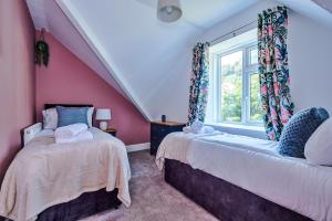 una camera con due letti e una finestra di Finest Retreats - Abbey Road House a Llandudno