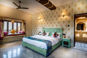 een slaapkamer met een groot bed en 2 ramen bij K D PALACE HOTEL in Jaisalmer
