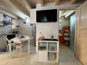 una cucina con tavolo e TV a parete di O' Vascio House a Napoli