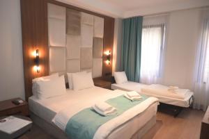 um quarto de hotel com duas camas com toalhas em Isle Hotel em Istambul