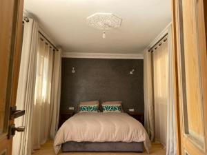 een slaapkamer met een bed en een kroonluchter bij Villa mirleft DEA in Mirleft