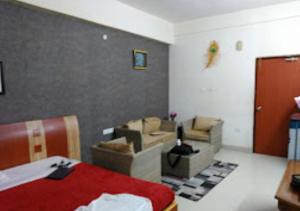 ein Schlafzimmer mit einem Bett und Sofas in einem Zimmer in der Unterkunft Hotel Shubham Odisha in Rourkela