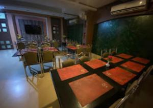 ein Esszimmer mit einem Tisch und Stühlen in einem Zimmer in der Unterkunft Hotel Shubham Odisha in Rourkela