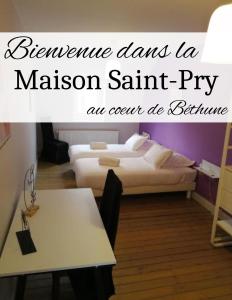 ベテューヌにあるLa Maison Saint-Pryのベッドルーム1室(ベッド1台、テーブル、ベッド1台、テーブル付)