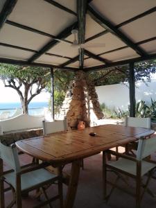 a wooden table and chairs under a tent at Costa dei Monaci Villas - Tropea in Parghelia