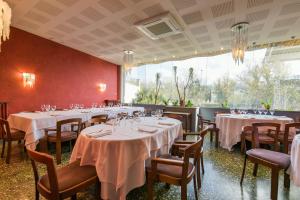 uma sala de jantar com mesas e cadeiras com toalhas de mesa brancas em Hotel Robert em La Pobla de Claramunt