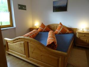 - un lit en bois avec des oreillers dans l'établissement Hinterbauernhof Fewo Pferdeglück, à Stegen