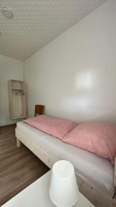 1 dormitorio con 2 camas con sábanas rosas y mesa en Highway Ferienwohnung, en Preußisch Oldendorf