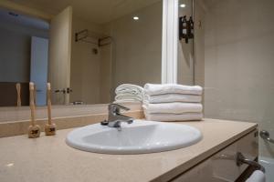 a bathroom with a sink and a mirror and towels at Hotel Alcossebre in Alcossebre