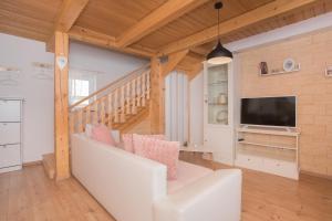 Kalpic Suites & Villa في لازوفاك: غرفة معيشة مع أريكة بيضاء وتلفزيون