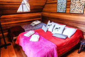 une chambre avec un lit avec une couverture rouge dans l'établissement Chalé São Bernardo - banheira de hidromassagem privativa, à Paiol Grande