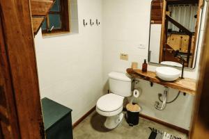 une salle de bains avec toilettes et lavabo dans l'établissement Chalé São Bernardo - banheira de hidromassagem privativa, à Paiol Grande 42 autres photos