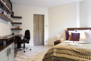 a bedroom with a bed and a desk and a chair at OLD CITY in BA/5*LUXUS/3xTV/BAR INTERNET in Bratislava