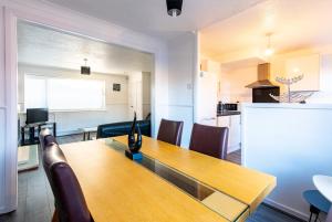 a kitchen and dining room with a wooden table and chairs at Redcroft Green - Modern 3 bedroom house in Kenton
