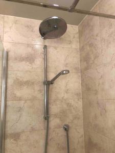 a shower with a shower head in a bathroom at 29 Comfort house 2 bedroom townhouse with parking in Scunthorpe