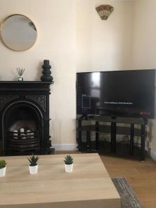 a living room with a large television and a fireplace at 29 Comfort house 2 bedroom townhouse with parking in Scunthorpe