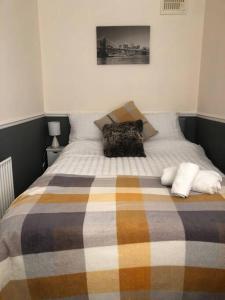 ein Bett mit einer Decke und zwei Kissen darauf in der Unterkunft 29 Comfort house 2 bedroom townhouse with parking in Scunthorpe