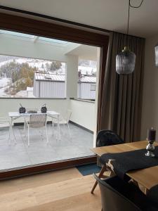 a dining room with a table and chairs and a large window at Cosy Apartment Marlain-Self Check in in San Valentino alla Muta