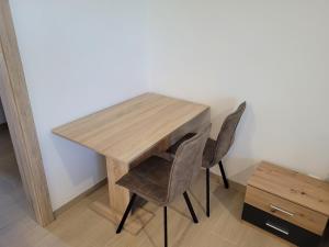 drewniany stół z 2 krzesłami i drewniane biurko w obiekcie Apartmán Neva Galanta w mieście Galanta